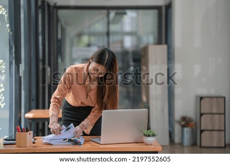 Asian businesswoman arranging documents on her desk