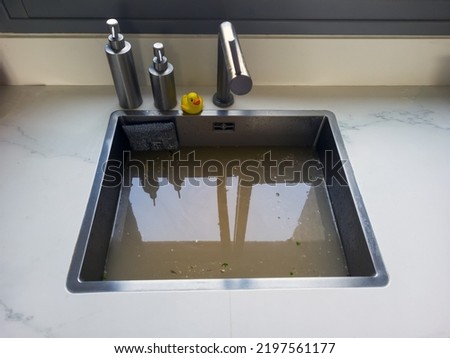 Overflowing kitchen sink, clogged drain. Plumbing problems. Royalty-Free Stock Photo #2197561177