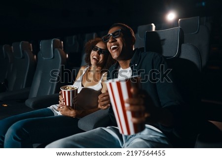 Young people in the cinema. People watch comedy. Young guy and girl are laughing.High quality photo