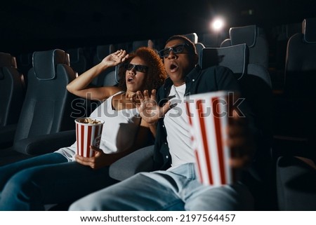 Young people in the cinema. People are watching a movie. The emotion of surprise.High quality photo Royalty-Free Stock Photo #2197564457