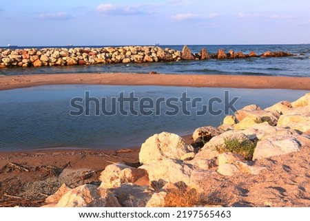 natural stony beach landscape in Spain with sand spit close up photo