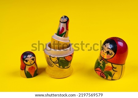 the matryoshka statuettes open on a yellow surface