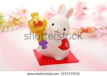 New Year's greeting card for the year of the rabbit. Horizontal version. The rabbit is holding a small mallet on which is written "FUKU" in Japanese. Royalty-Free Stock Photo #2197574521