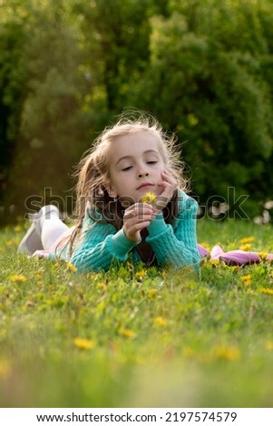 A little girl in a green dress with spring flowers. Spring. Nature.