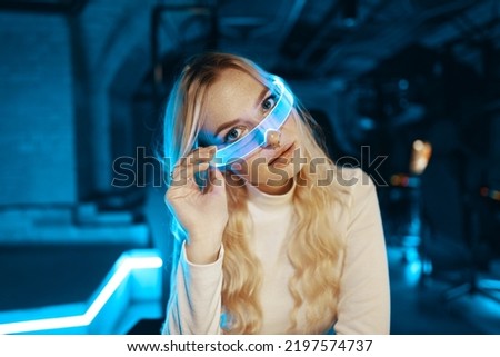 Young woman puts on neon 3d virtual reality glasses. High quality photo