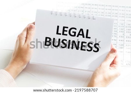 Businessman holding notepad on desktop background with text Legal business