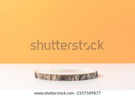 Wood slice podium on orange background. Concept scene stage showcase, product, promotion sale, presentation, beauty cosmetic. Wooden stand studio empty. Minimal composition