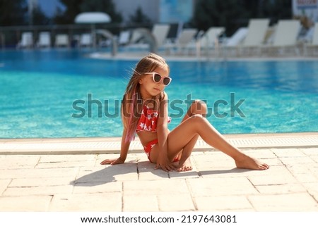 Beautiful girl in a red bikini near the pool. Travel concept.