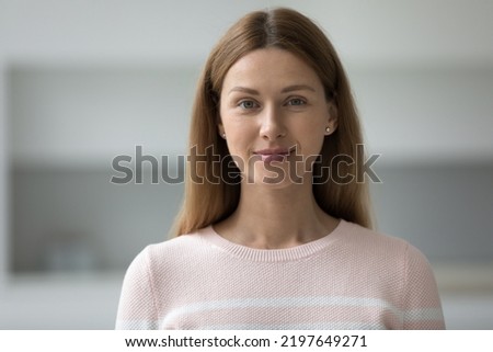 Positive pretty adult female model head shot portrait. Beautiful Caucasian woman with natural makeup, long brown hair in casual looking at camera, posing at home. Front profile picture