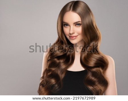 Beauty girl with long  and   shiny wavy hair .  Beautiful   woman model with curly hairstyle . Royalty-Free Stock Photo #2197672989