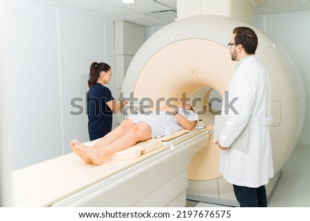 Female patient getting a medical test at the hospital and doing a magnetic resonance to check for cancer with a doctor and radiologist Royalty-Free Stock Photo #2197676575
