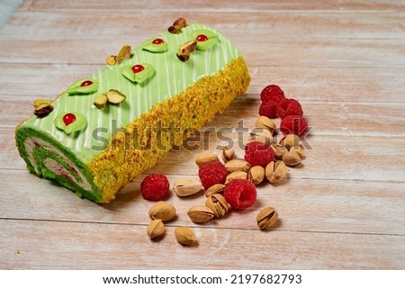 pistachio raspberry roll or swiss dessert cake on light background