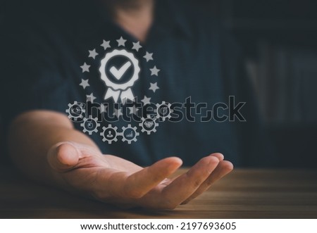 ISO certification concept. Hand showing the excellent standard score with ribbon after passed the evaluation or certified audit in organization or factory or company to guarantee the service quality. 