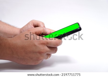 man hands holding smart phone with green screen for design