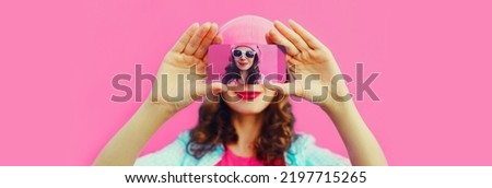 Close up of woman stretching her hands taking selfie with smartphone on pink background