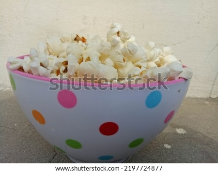 This is a beautiful picture of tasty popcorn served in polka dots bowl.
