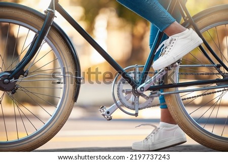 Bike, shoes and cycling with a woman cyclist riding her bicycle outside on the road or street during the day. Sport, exercise and fitness with a female rider on transport with wheels and pedals Royalty-Free Stock Photo #2197737243