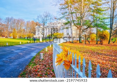 Morning landscape in autumn park. Orange red maple leaves on road. White house on background. Fall season nature scene beauty. Yellow tree alley in city garden Scenery path, sun street. Bunch in fence Royalty-Free Stock Photo #2197745933