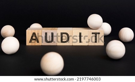 Business and economy concept. On a black surface and wooden cubes with the inscription - AUDIT