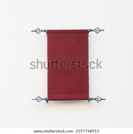 Blank canvas poster post on the wall. Vintage maroon red sign with copy space. medieval inscription for building Royalty-Free Stock Photo #2197748915