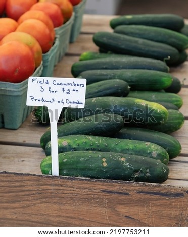Close up photo of cucumbers and tomatoes being sold at a farmer's market in Ottawa, Canada.
