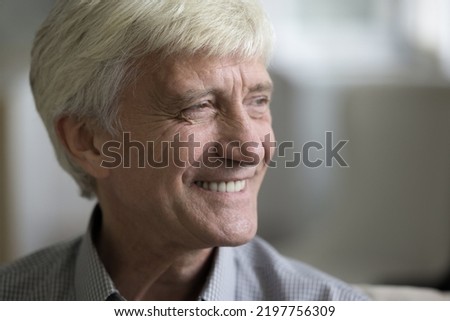 Happy mature grey haired man looking away with toothy smile, thinking, dreaming, feeling joy. Face of joyful dreamy elder 70s grandpa with wrinkles close up portrait. Elderly ag Royalty-Free Stock Photo #2197756309