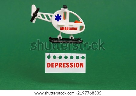 Medical concept. On a green surface, an ambulance helicopter with a sign - DEPRESSION