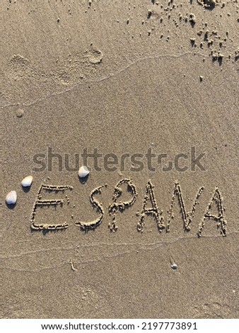 on the beach is carved with letters in the smooth sand the writing Espana