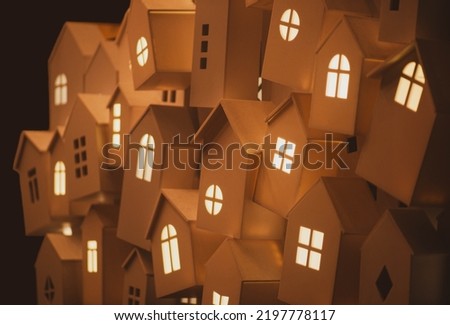 light from the windows of small decorative, white houses on the street of a European city during the winter seasonal holidays