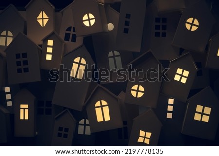 yellow light from the windows of small decorative houses on the city street