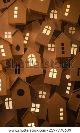 light from the windows of small decorative, white houses on the street of a European city during the winter seasonal holidays