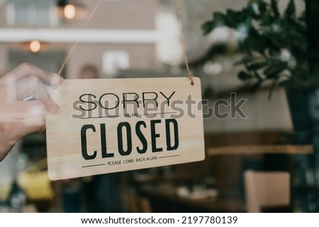 Business coffee cafe shop sign board is hang on door and show close shop with cafe and restaurant blur bokeh background.