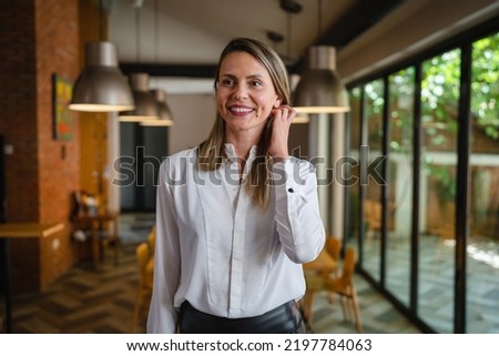 One woman middle age caucasian female standing at home in dining room or restaurant happy smile confident wear white shirt waist up copy space front view portrait