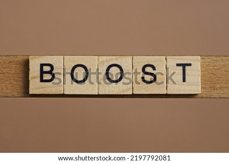 word boost from wooden letters lies brown backgound