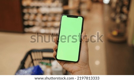 Overlooking the green screen of the phone in front of the shelf