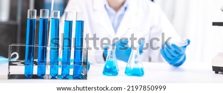 blue chemical liquid experiment in scientific glassware equipment in science medicine laboratory, chemistry or biology research discovery by using glass of test tube or beaker and flask