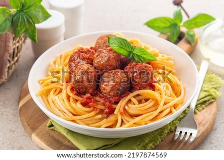 Spaghetti and beef Meatballs with tomato sauce in white dish on wooden rustic board, Italian-American food. Close-up. Royalty-Free Stock Photo #2197874569