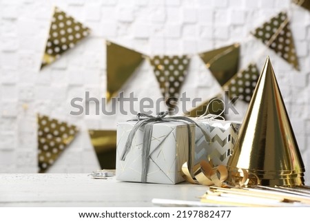 Gifts and party cones on table against blurred background