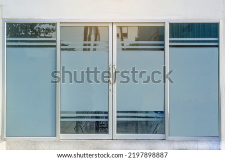 Glass or Aluminum door , double swing, clear glass with gray light filter film, door concept, aluminum, glass and home decoration accessories. Soft and selective focus.                               