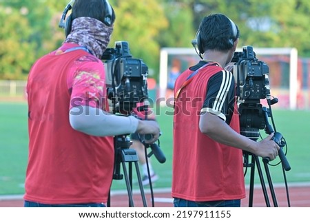 Cameraman shooting soccer game.Professional sport media at the stadium during football matches.TV media broadcasting during the sport tournament.
