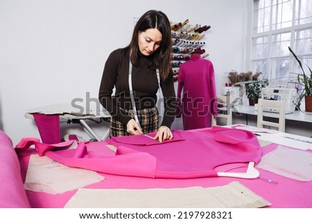 Seamstress working with sewing pattern on table in tailor shop Royalty-Free Stock Photo #2197928321