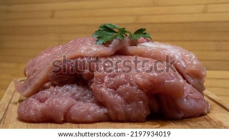 Slices of meat stacked on top of each other in the form of a mountain, on top of a leaf of parsley. Background picture.