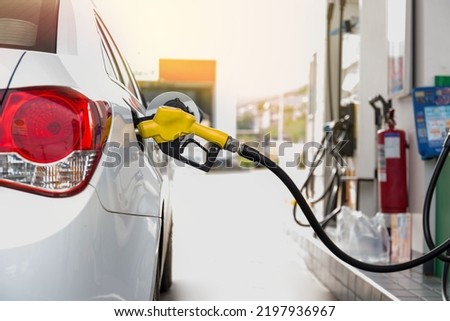 Closeup of people pumping gasoline fuel in car at gas station. Petrol or gasoline being pumped into a motor vehicle car.  Royalty-Free Stock Photo #2197936967