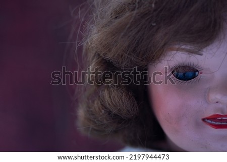 Close up on a scary vintage doll isolated on black background. focus on the eye. Halloween concept.Horror concept of an old doll.
