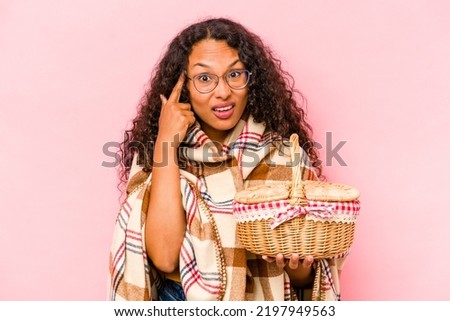 Young hispanic woman doing a picnic isolated on beige background showing a disappointment gesture with forefinger.
