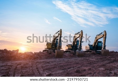 A large construction excavator of yellow color on construction site in quarry for quarrying. Industrial image. Excavator with Bucket lift up digging the soil in the construction site on sky background Royalty-Free Stock Photo #2197950721