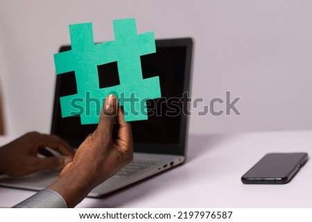 african businessman holding a hash tag symbol