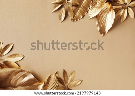 Golden leaves fashion floral minimal concept. Stylish natural background for design and decoration top view. Royalty-Free Stock Photo #2197979143