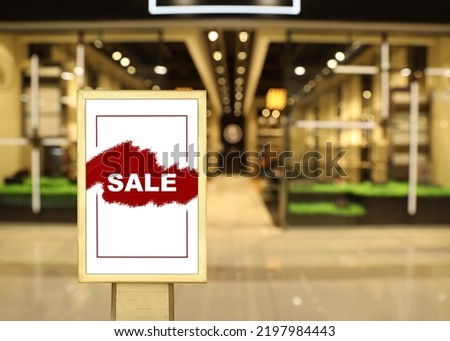 Advertising board with text SALE in shopping mall. Special promotion