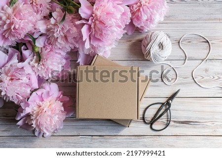 Brown cardboard boxes and a bouquet of peonies. Package box for branding. Mock up gift boxes